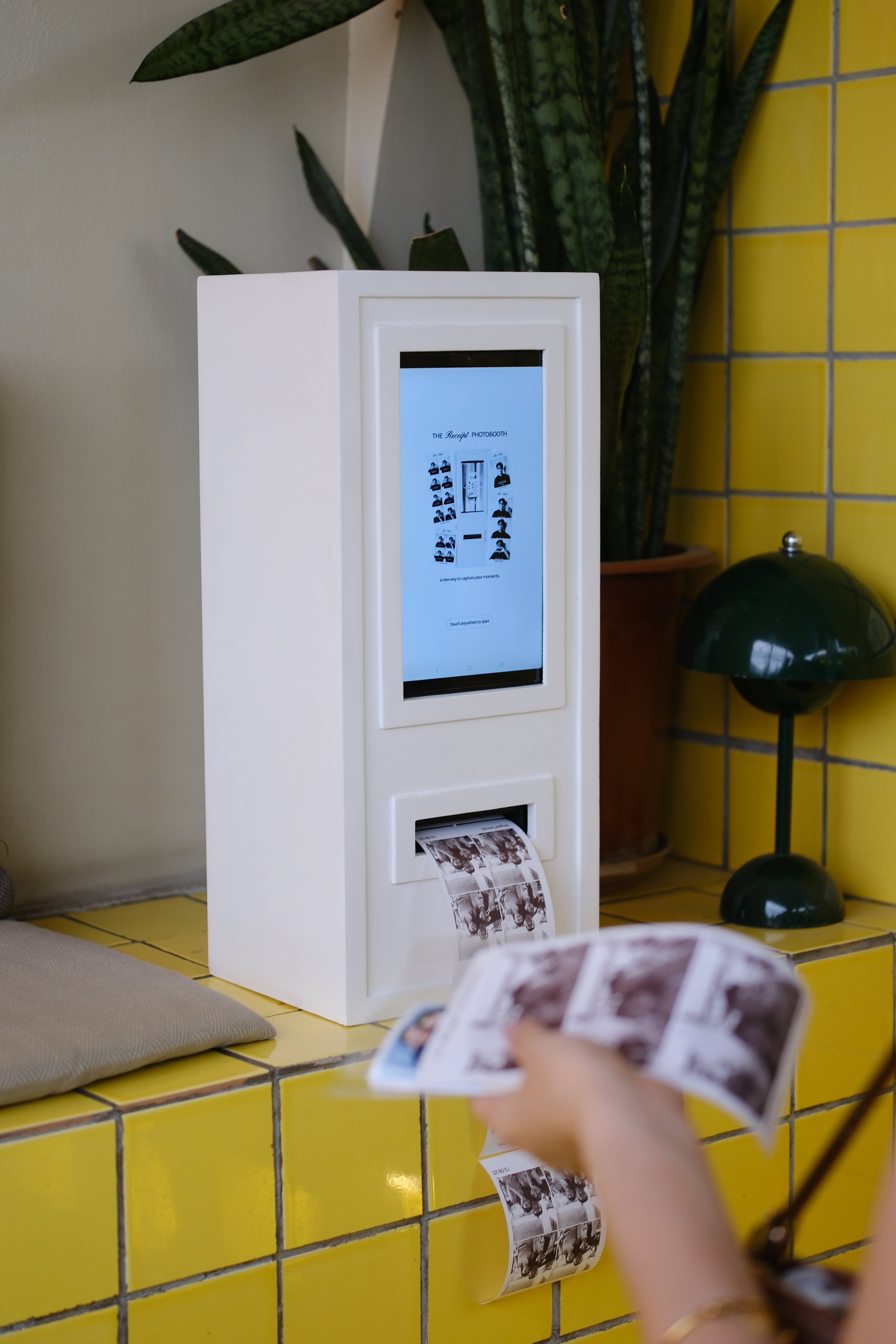A receipt photo strip emerging from the booth printer slot